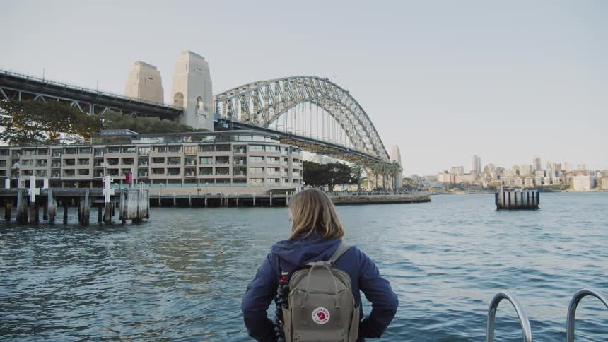 A woman looks at a city river