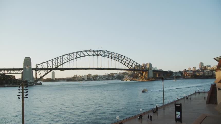 A speedboat is navigating a river near a city during the day