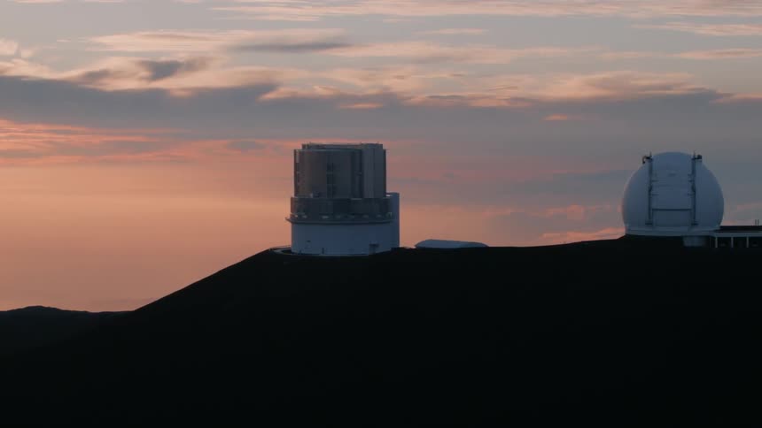 Clouds are hanging in the sky above an observatory at dusk