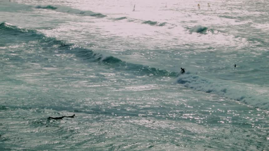 A man is surfing under the bright sun