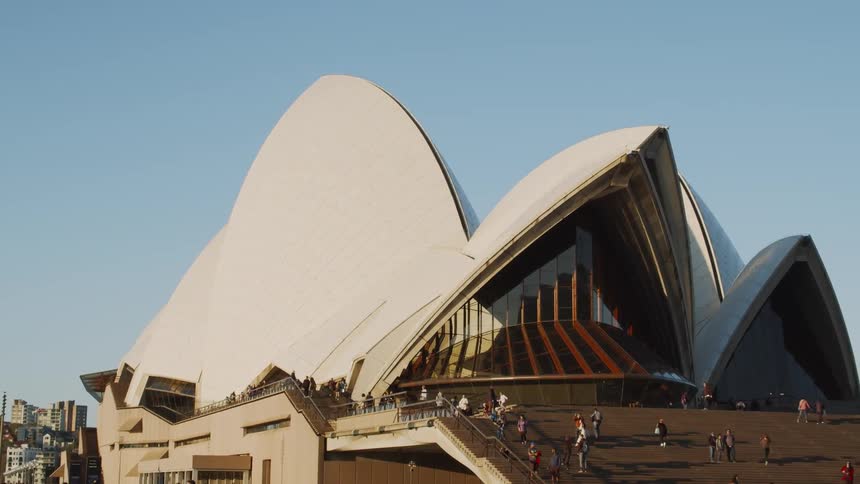 People walk up the stairs towards a building