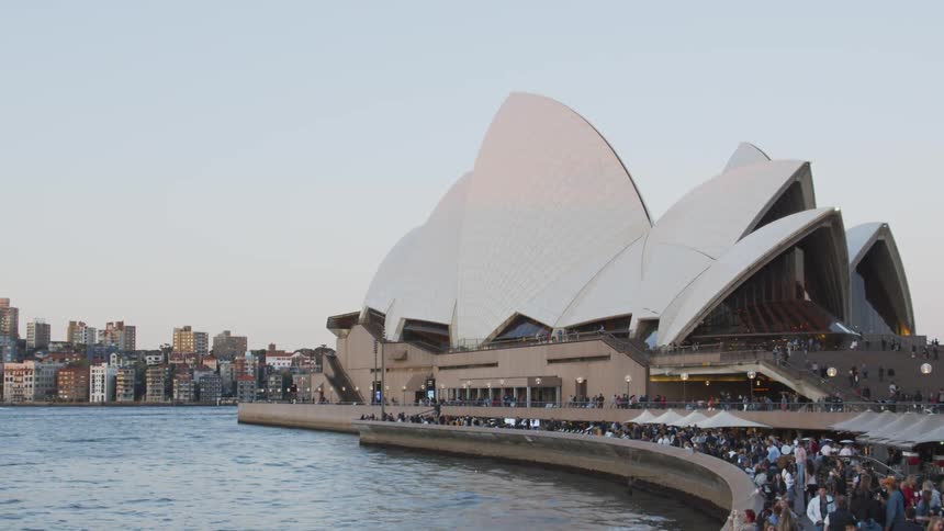 People walk along a building on the city pier
