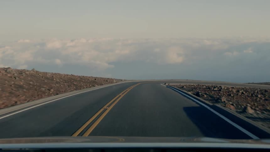 A vehicle travels on a mountain road
