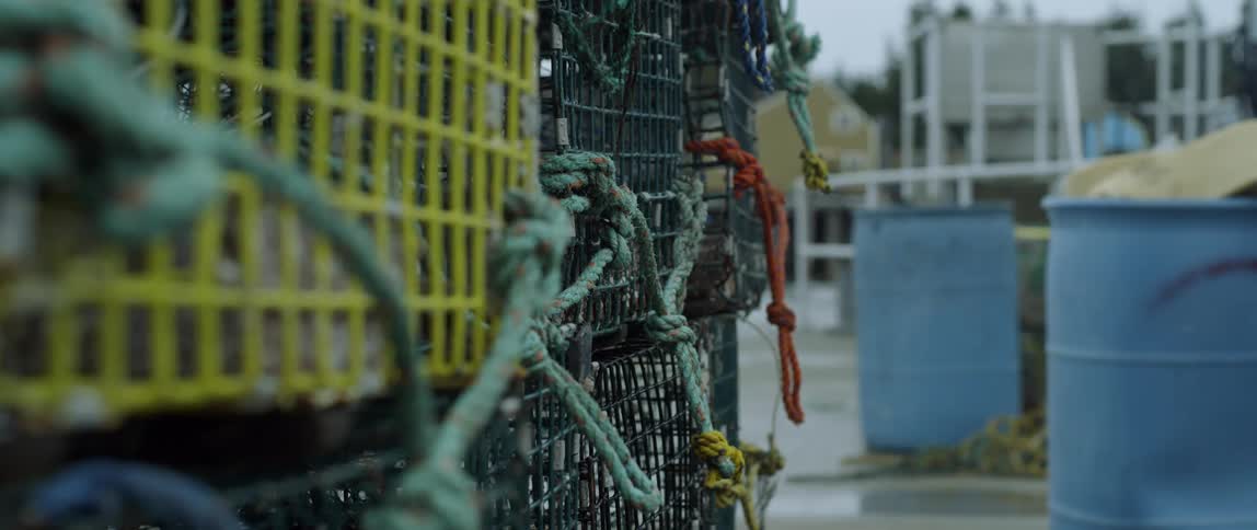Crab pots stacked up outside near a body of water