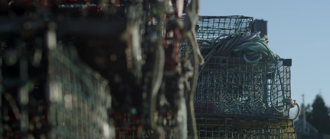 Crab pots stacked up outside on a sunny day