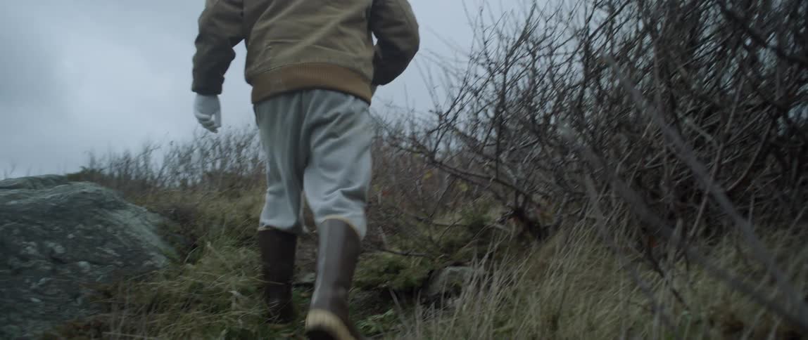 A man in boots hikes in a rural area