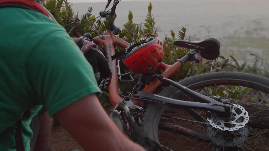 A man pets a dog next to his parked bike