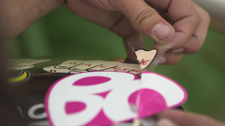 Person trims a decal onto their skateboard