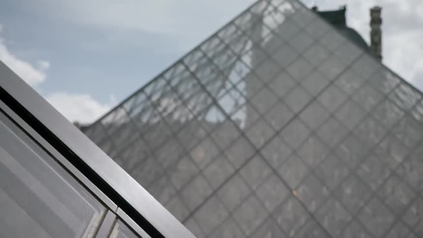 Clouds float above the louvre pyramid