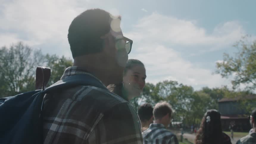 A man and woman talk while walking outside