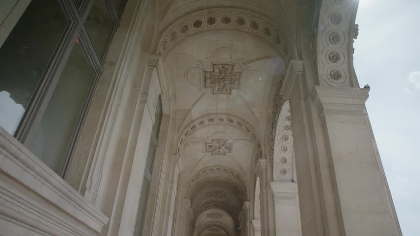 Walkway on the outside of a building with arched stone overhead