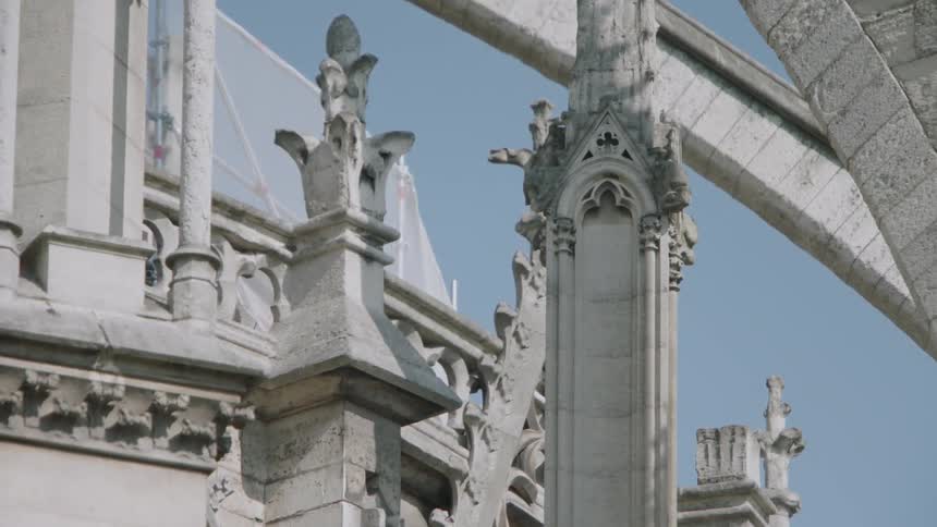 Very ornate building on a clear day as a bird flies by