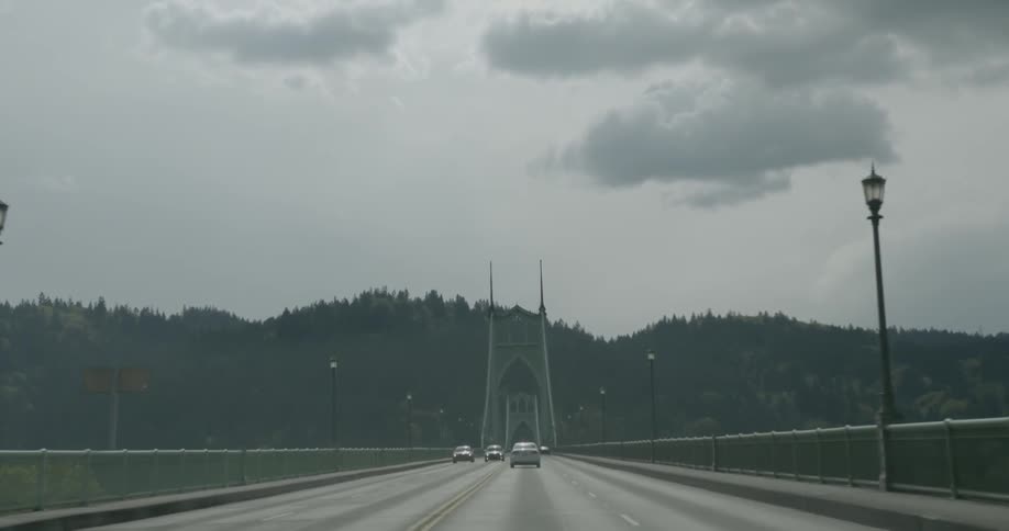 Vehicles traveling over a bridge on a cloudy day