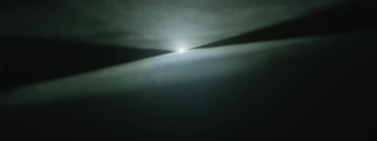 Light shines through smoke in the dark
