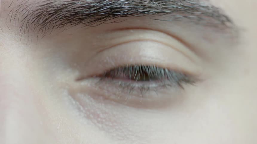 Light moves across a person's closed eye and then opened eye