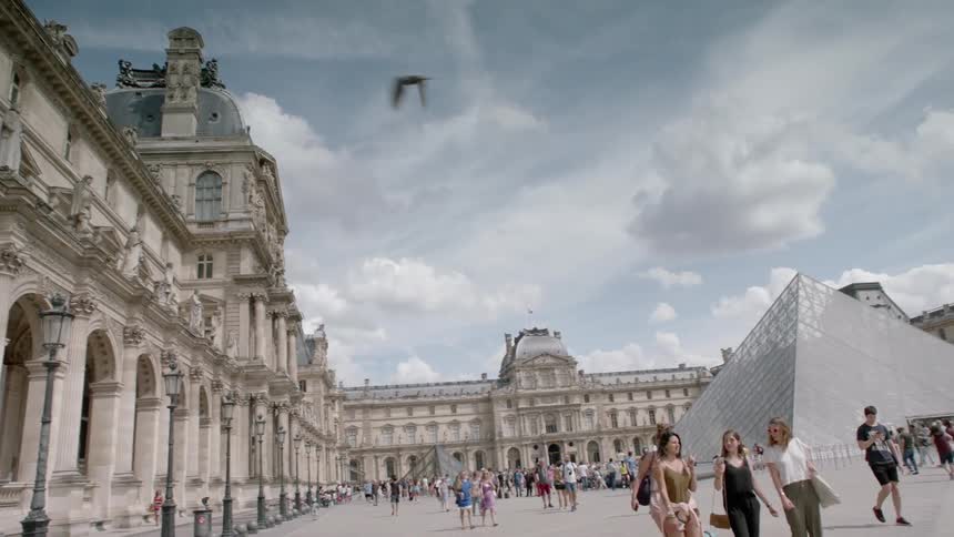 People walk outside at the louvre museum