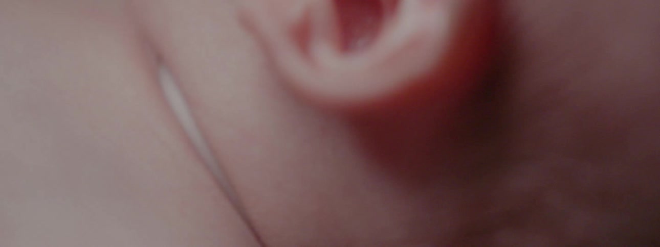 A baby's ear and head fades to black