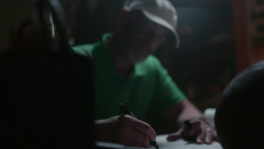Man works at at desk in a dark room