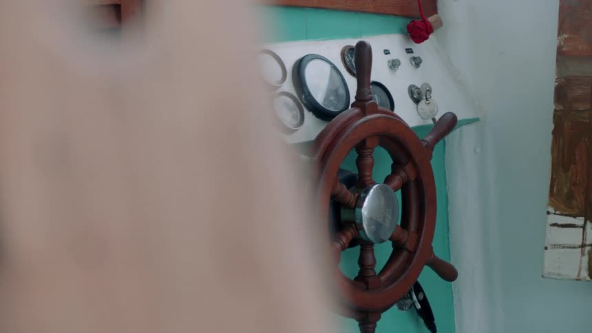 Ship steering wheel next to more instruments