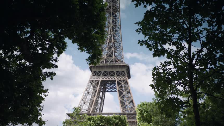 People walk beneath the eiffel tower