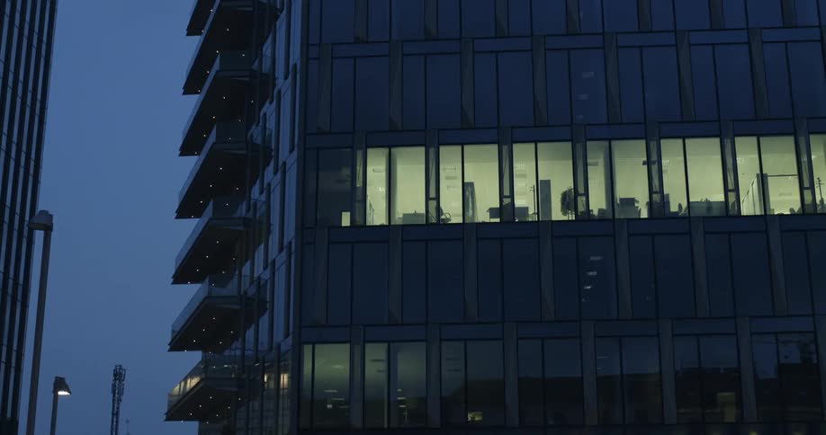 Lights shine from a city office building at night