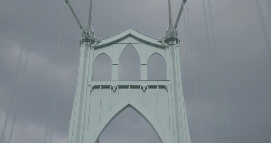 View of a cloudy sky over a large decorative suspension bridge