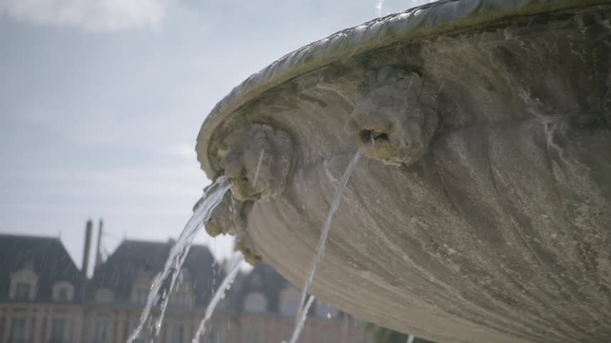 Water is cascading and flowing in a fountain in a park on a sunny day