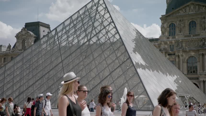 People walk outside at the louvre museum
