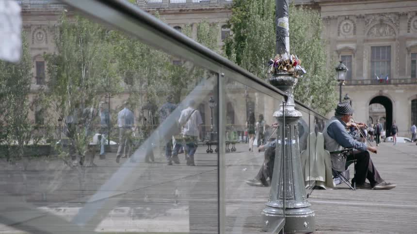A violinist plays on a city bench