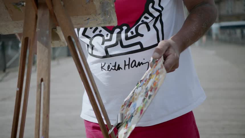 An artist paints outside in a city