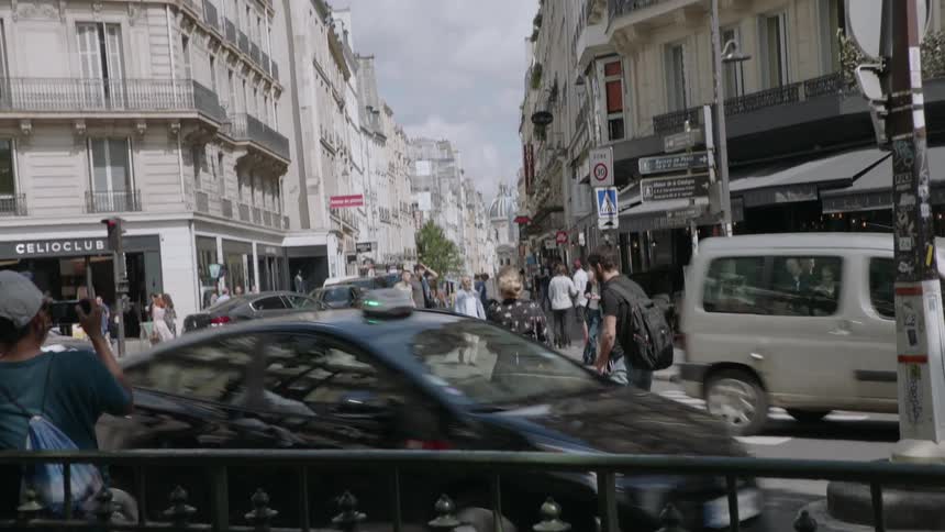 People travel by foot and car on a busy city road