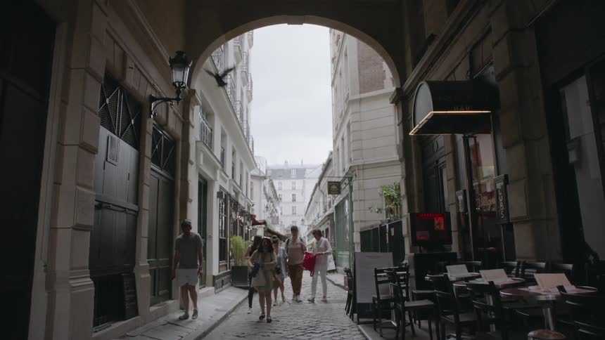 People walk on a cobblestone city alley