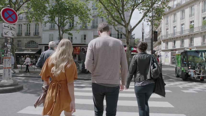 People walking in the crosswalk of a busy city street