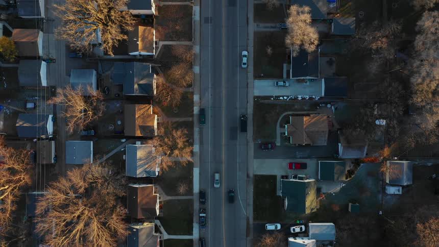 Cars drive through a neighborhood