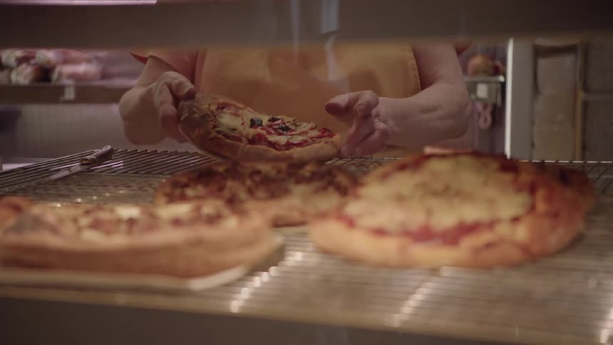 A woman cooks pizzas in a restaurant