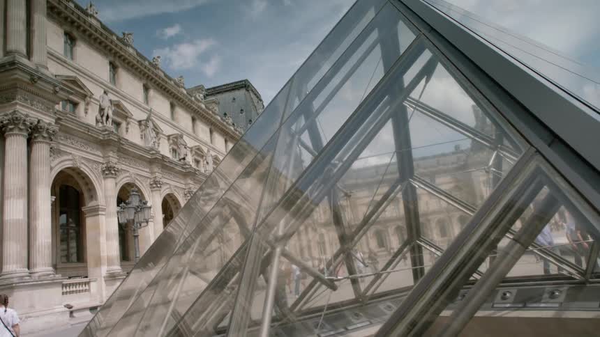 Triangular glass building in a city square
