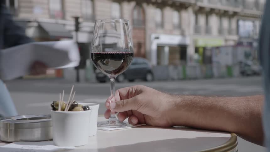 Man drinks wine on a restaurant patio