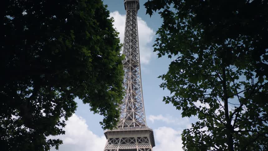 Tall tower in between two trees on a cloudy day