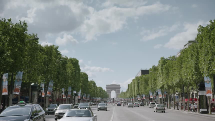 Cars pass along a street near the arc de triomphe