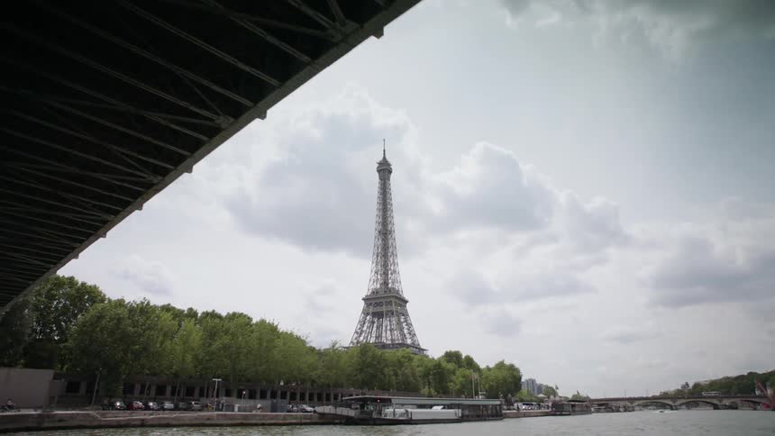 A boat floats on a river near the eiffel tower
