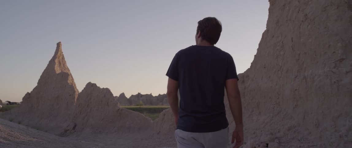 A man walking between rock formations