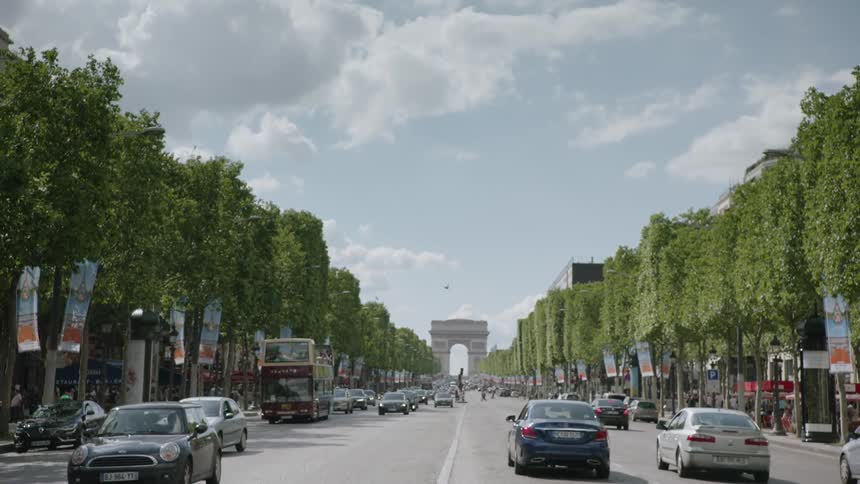 Vehicles travel down a busy city street