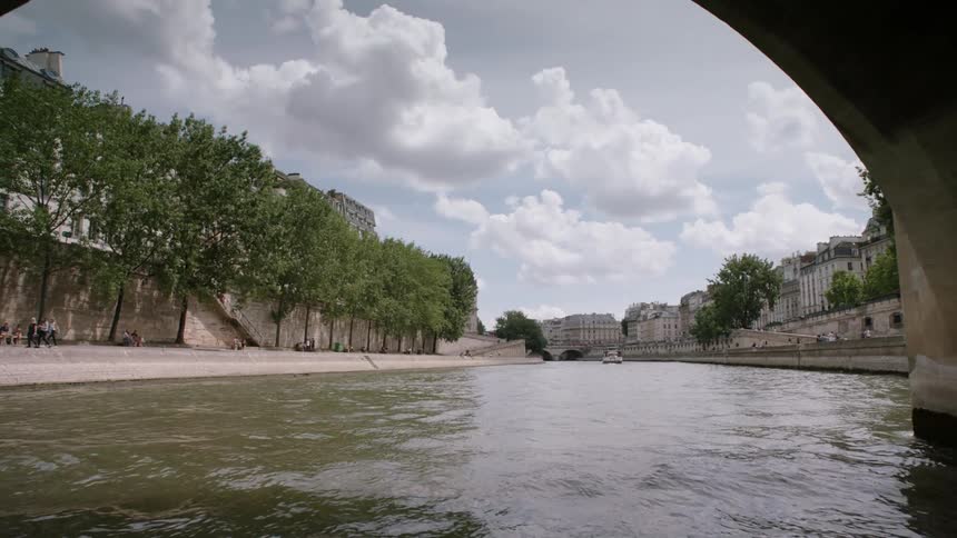 Boats travel through a bridge on a city canal