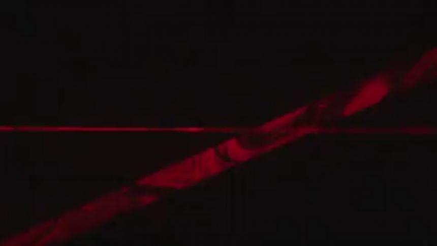 Multi-colored lasers are shined outside under moonlight