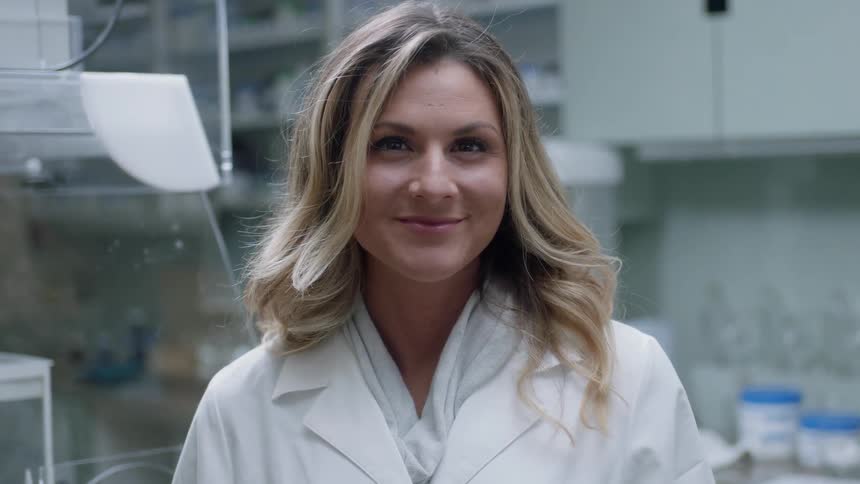 A woman is smiling while looking at the camera