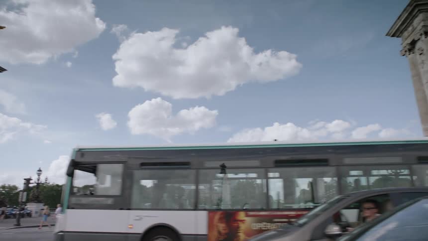 Pedestrians and cars travel in a city