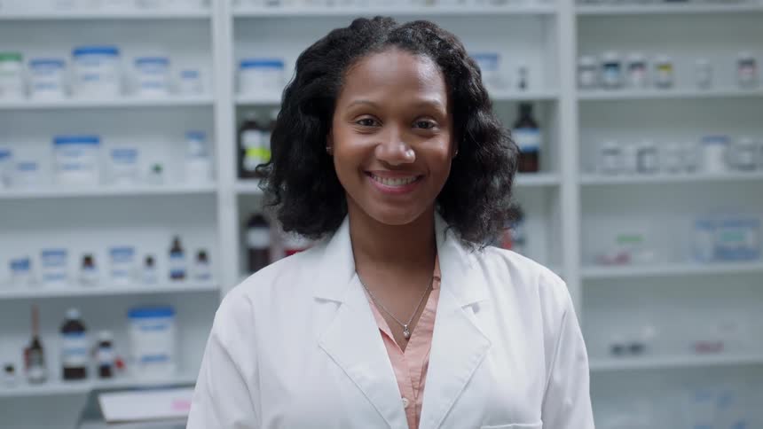 A pharmacist smiles in a pharmacy