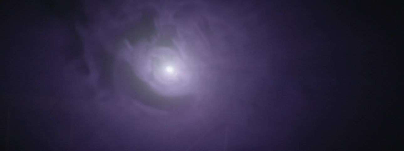 Smoke floats in front of strobe lights in the dark