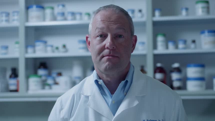 A pharmacist stands in a pharmacy