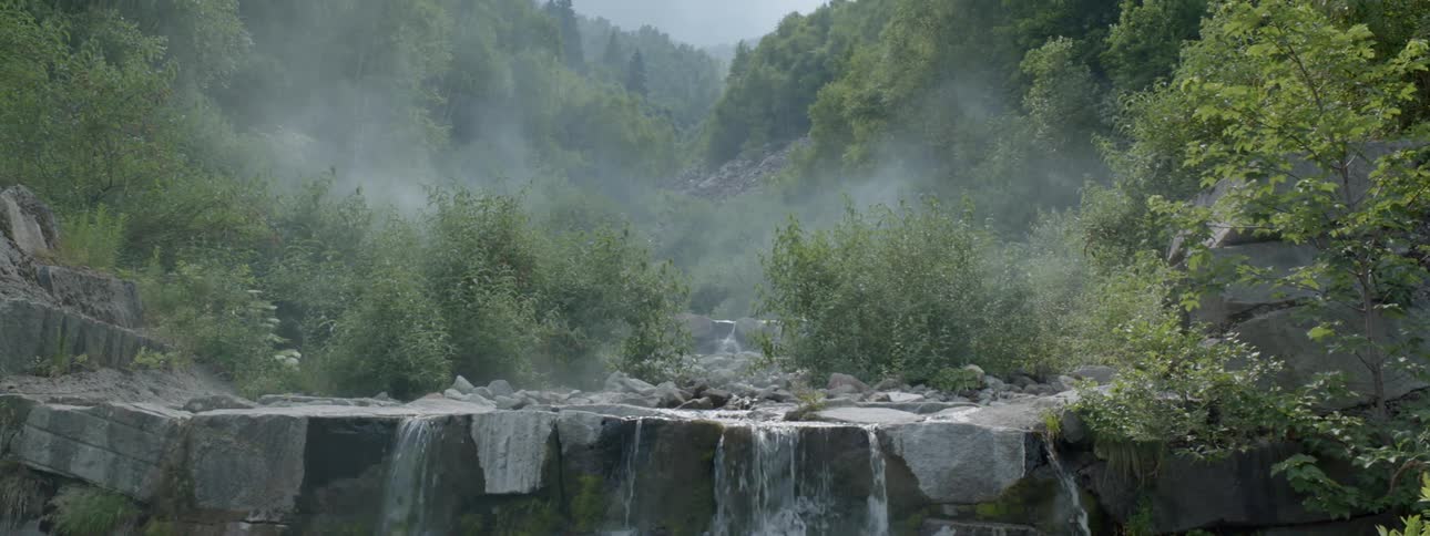 Water flows over a cliff in the mountains